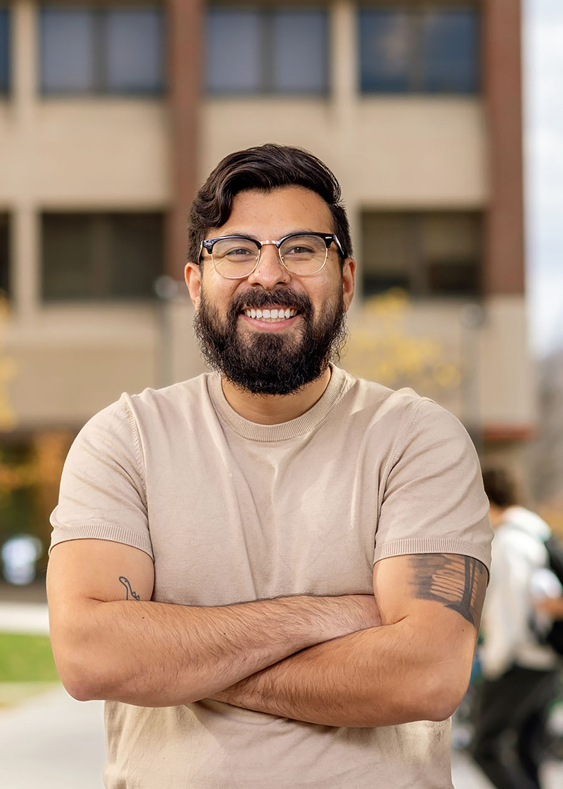 Jurgen Baeza Banal in front of a Syracuse University building smiling.